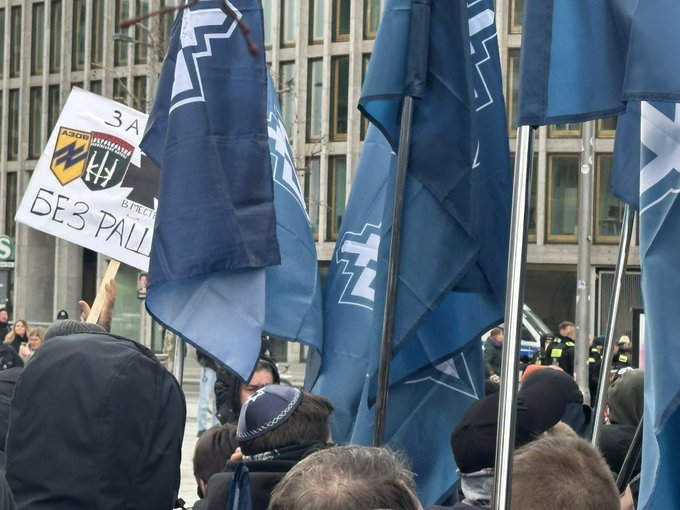Insignia of the Russian Nazis of the "Russian Volunteer Corps" fighting for Ukraine, and of the Ukrainian Nazis of Azov and Right Sector are exhibited  during the demonstration attended by american transgender "Sarah" Ashton-Cirillo. 

In Germany it is a crime to display Nazi