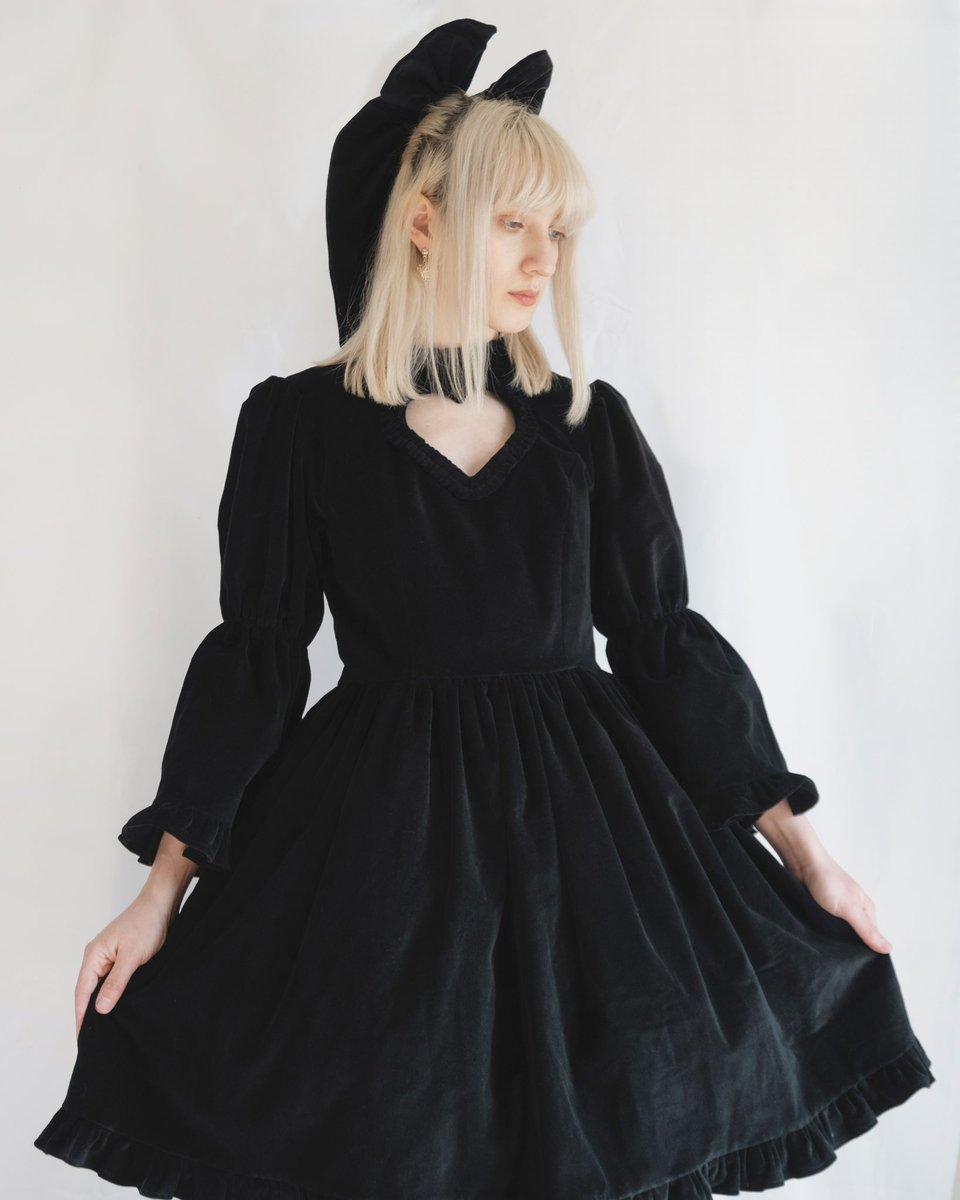 Our new collection features a black one-piece dress with a heart cut-out! Made from cotton velvet with a soft cotton lining, it has a ruffled high neckline, adjustable bell sleeves, pockets &amp; a charming cut-out. Available in 4 colors &amp; 5 sizes—pre-order by March 17!