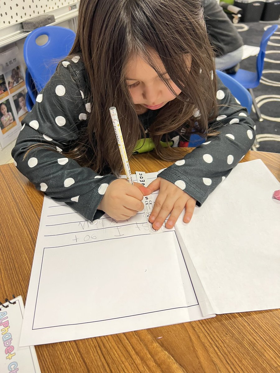 Kindergarten writers working on writing two sentences on each page.