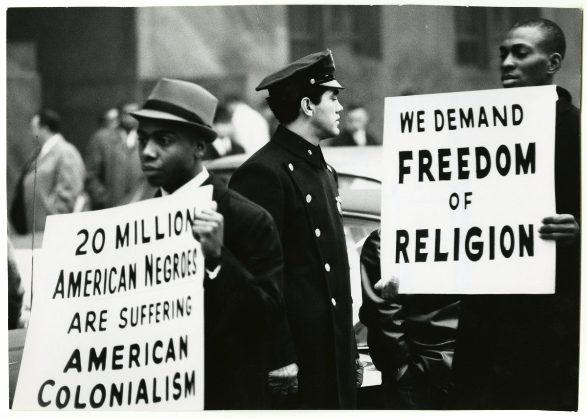 WHITE POLICE OFFICER STANDING BETWEEN TWO BLACK PROTESTORS, Gordon Parks, 1963