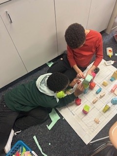 "Ms. Stephen's class is on to the next steps of their city planning project! Now they are considering goods, services and productive resources as they begin to add parks, streets, specific budlings for the community, and traffic lights!  🌆 #CityPlanning #Education #STEM"