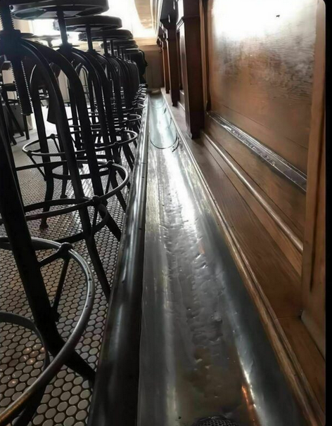 True or false?

Old timey bars used to have a urinal trough and you could just whip it out and pee while you drink. Like on the following photo