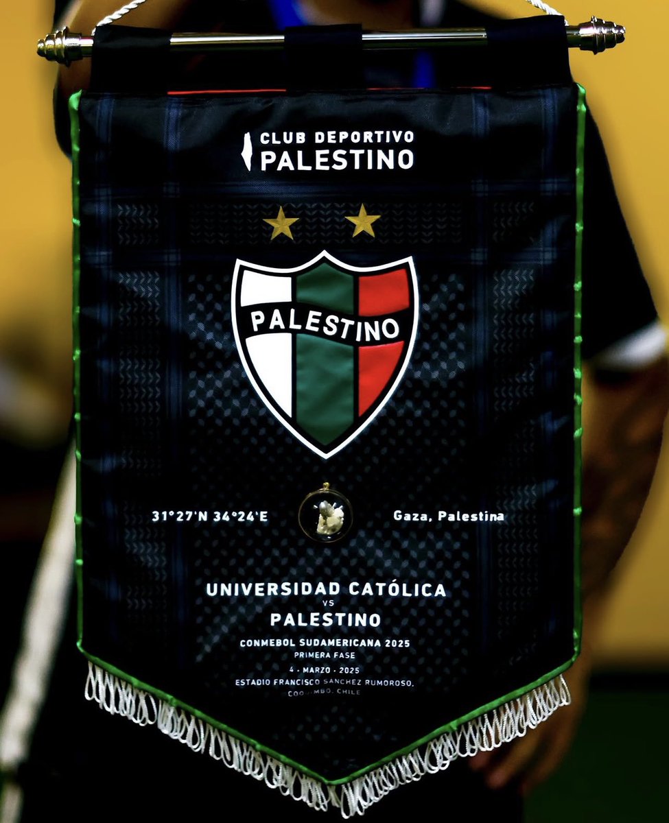 FutboliPolitica's tweet photo. 🇨🇱En comienzos del 2024, la casa del médico palestino Anas Mohamed Tahir fue bombardeada y destruida por completo en Gaza.

Un pequeño trozo de esos escombros viajó más de 13 mil kilómetros para que el club @CDPalestinoSADP lo incrustara en el banderín que le entregaron al rival. https://t.co/m3eBYtFsG3