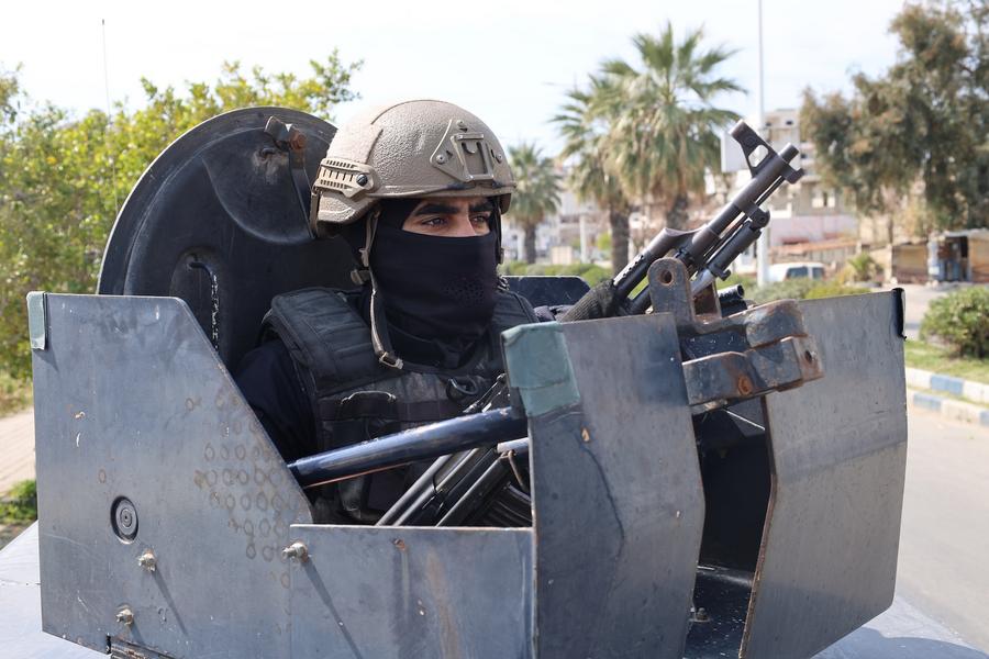 أفراد قوات الأمن السورية في دورية في شارع في مدينة جبلة الساحلية بمحافظة اللاذقية شمال غربي سوريا.xhtxs.cn/1O5