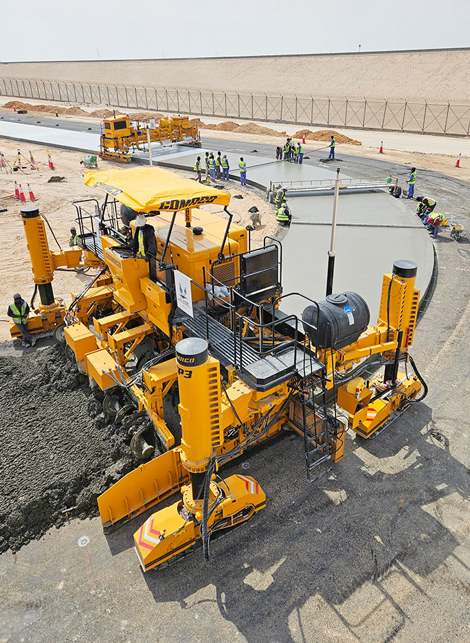 GOMACO's tweet photo. A GOMACO four-track GP3 is slipforming a truck parking area near the Al Ghuwaifat Port Station in the United Arab Emirates. The paver is equipped with Leica 3D guidance, a 5400 series tie bar inserter, and magazine-style side bar inserters. 

Photos By AL NISR https://t.co/sao49d9y4F
