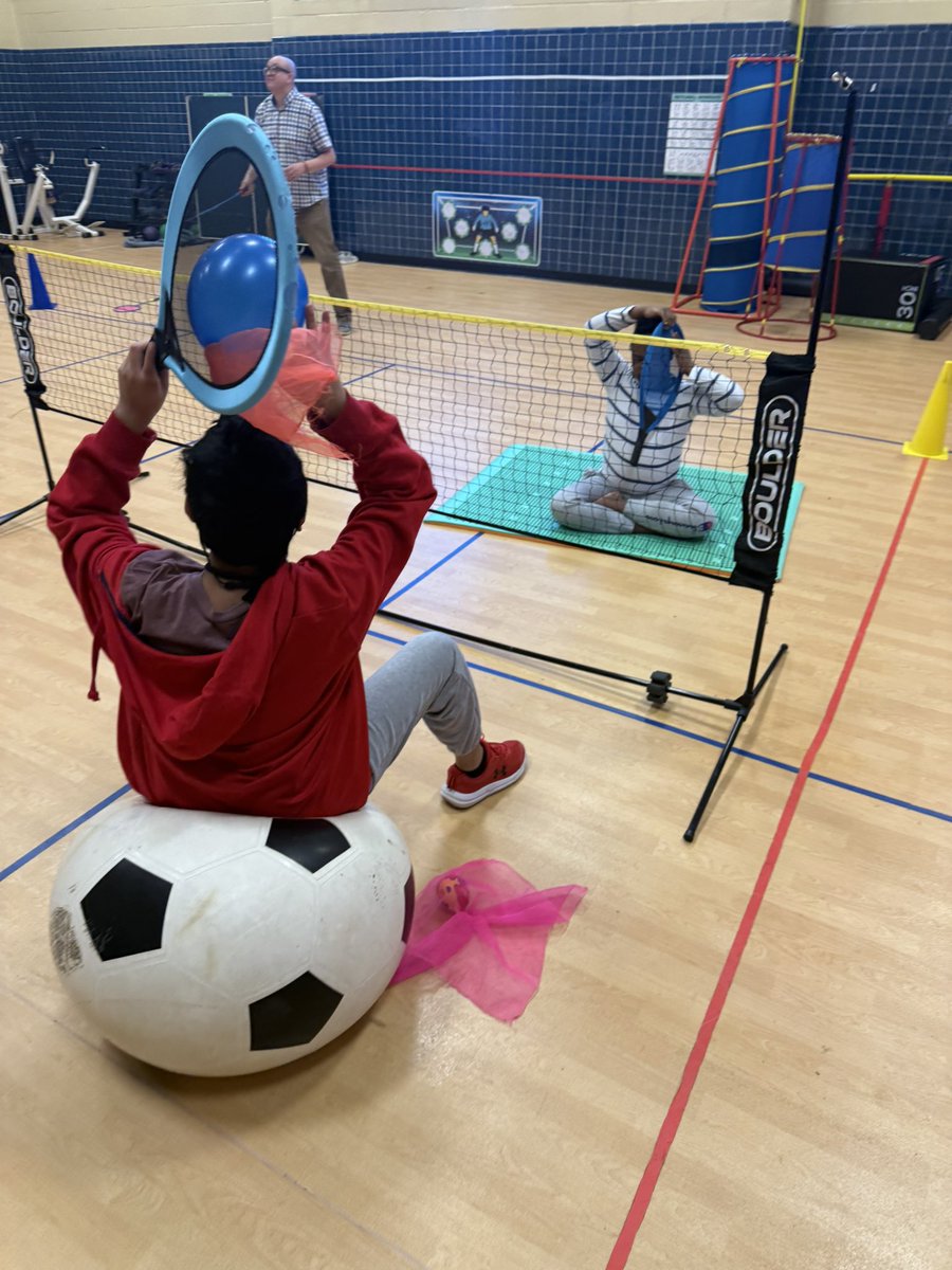 DigitTheAPE's tweet photo. Adapted Badminton with the STEP Model!

✔️ Space: Seated on a sensory moon mat &amp; exercise ball
✔️ Task: Controlled volleys over a lowered net
✔️ Equipment: Adapted racquets, enlarged birdie &amp; balloon birdie
✔️ People: Staff assisting for success

#AdaptedPE https://t.co/P2yB1RaZts