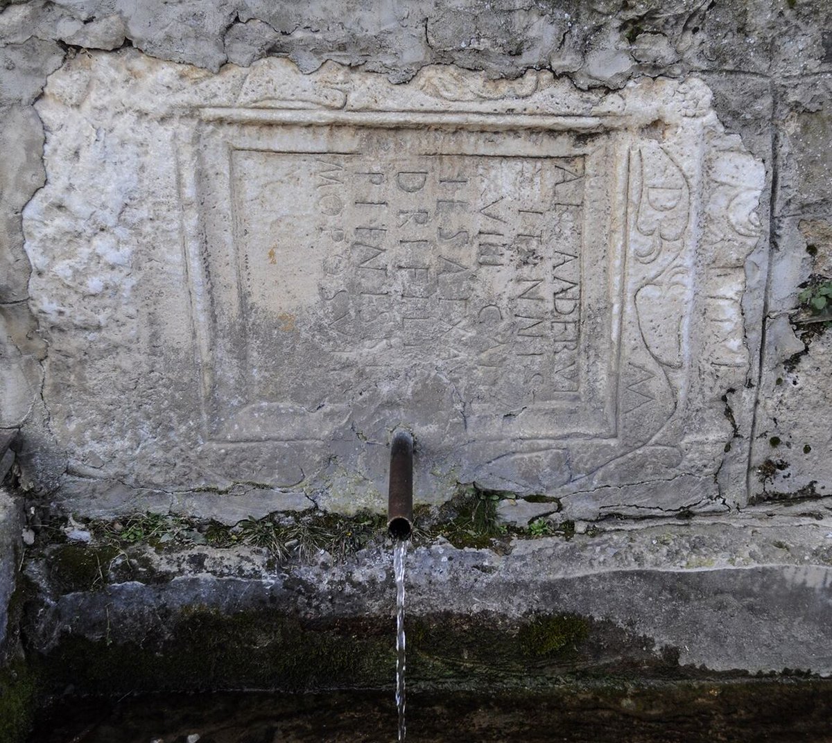 Macedonicon's tweet image. The fountain in Dolno Sonje, near Skopje, flows out of an ancient Roman gravestone. The Latin inscription is dedicated to a person named Alexander who lived to be 19 years old.