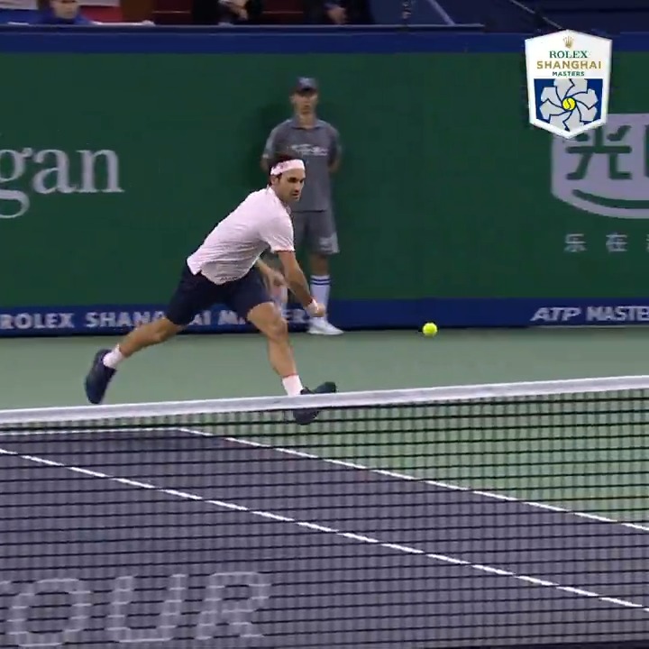 A male tennis player wearing a white shirt and headband is shown mid-stride during a match at the Rolex Shanghai Masters.
