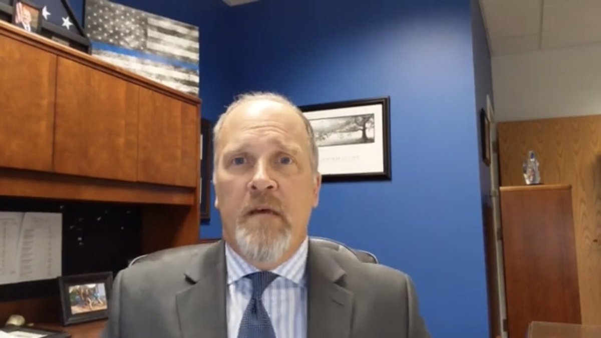 Brad Schimel has a “thin blue line” / police non-accountability altered American flag in his office