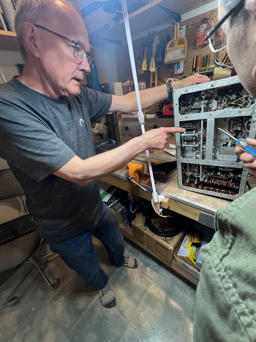 Ken Hill VE6AGD and Jerry Spring VE6TL examining a WW2 vintage aircraft vacuum-tube radio originally installed in an Avro airplane.