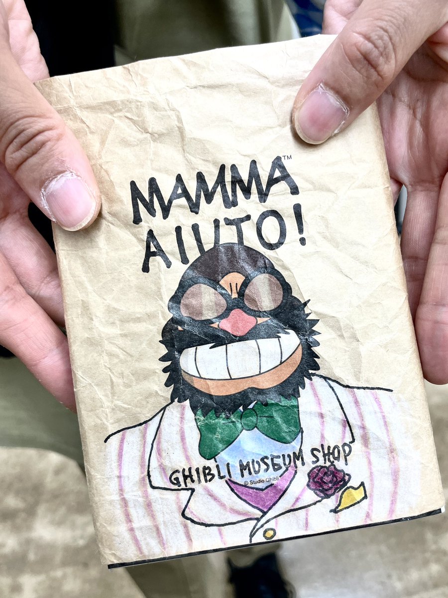見た事のないブックカバーの本を読んでいた谷合さん。 ショップの平袋 