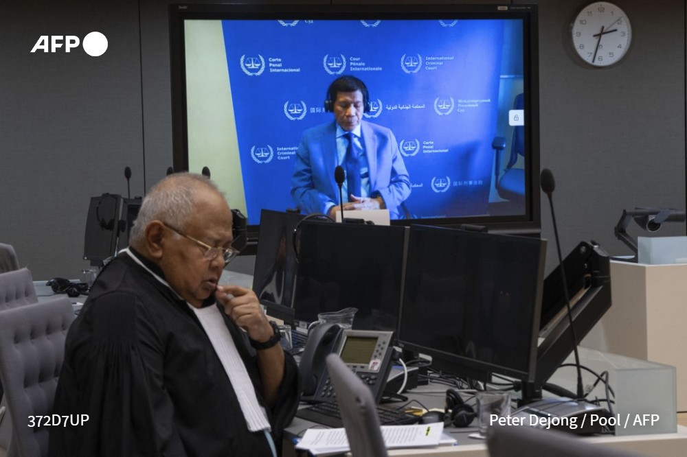 Philippine ex-president Rodrigo Duterte is seen on a videolink with his lawyer Salvador Medialdea (L) in the courtroom during his first appearance before the International Criminal Court (ICC) in The Hague on March 14, 2025