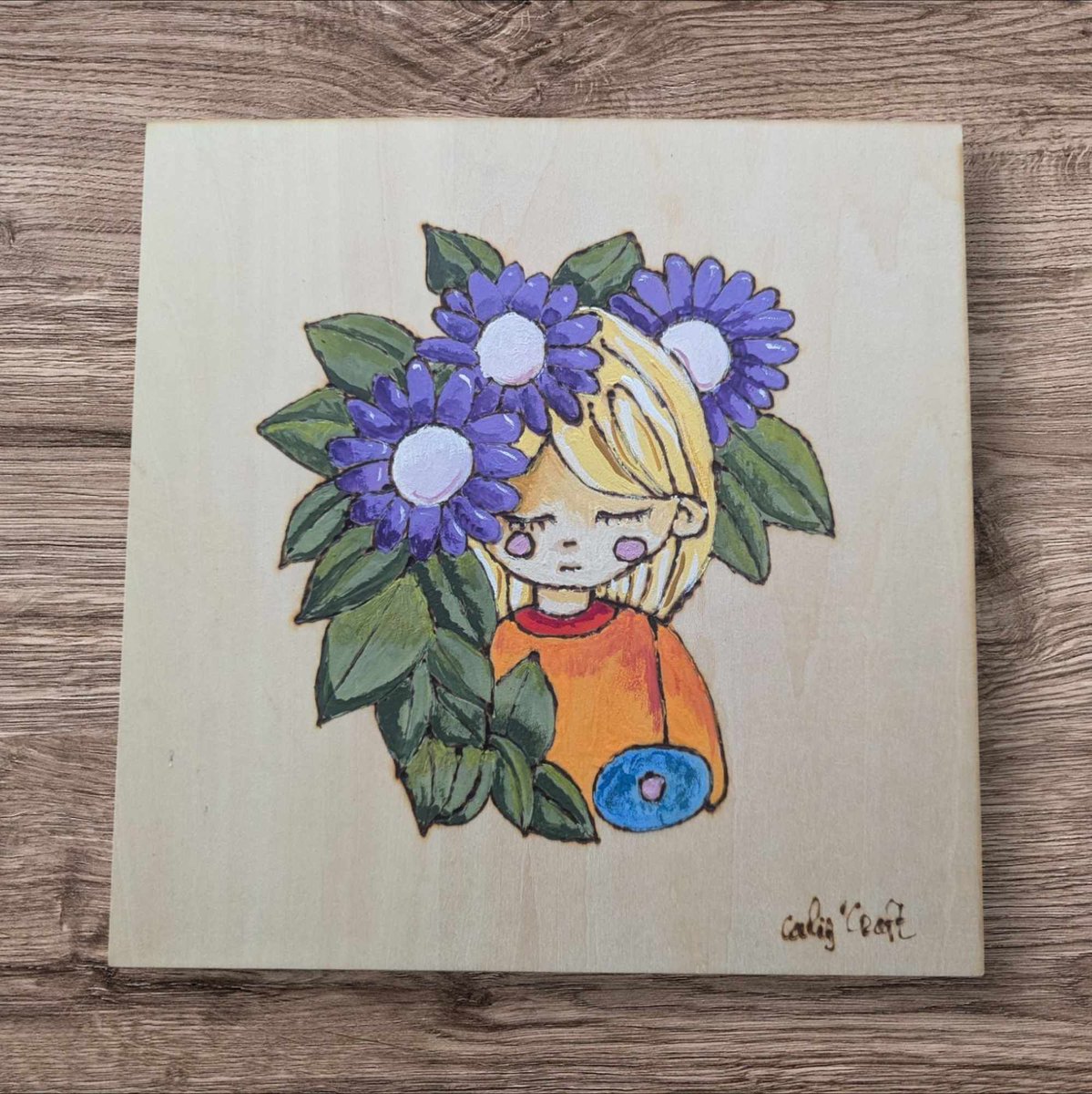 CaliUny's tweet photo. Découvrez en boutique un tableau exceptionnel : une jeune femme blonde ornée de fleurs violettes, pyrogravée sur une planche de bouleau et peinte à la main. Chaque détail de cette œuvre unique est soigneusement réalisé, rendant ce tableau vraiment singulier. #ArtUnique #FaitMain https://t.co/A6dDVUTCiS