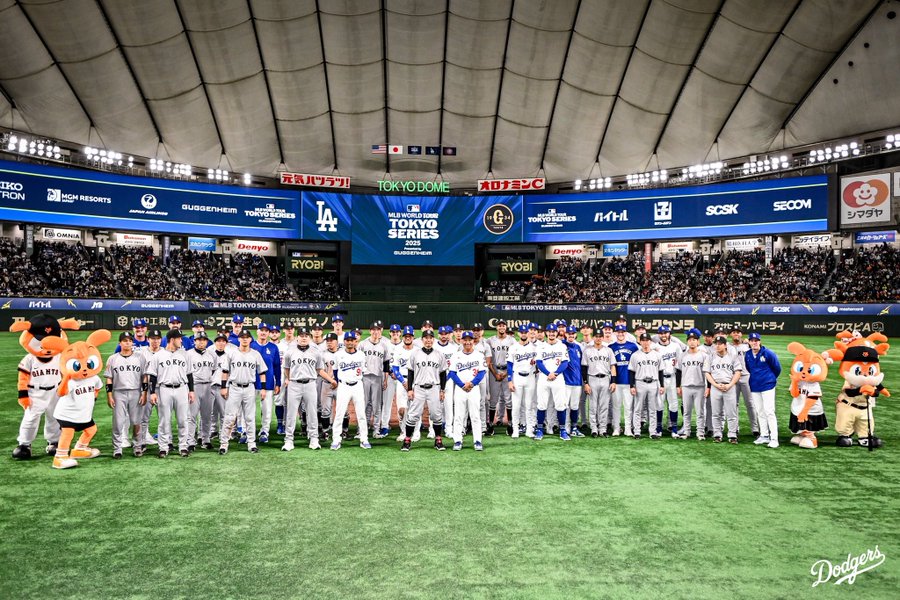 A team photo of the Dodgers and the Yomiuri Giants on the field after the game.