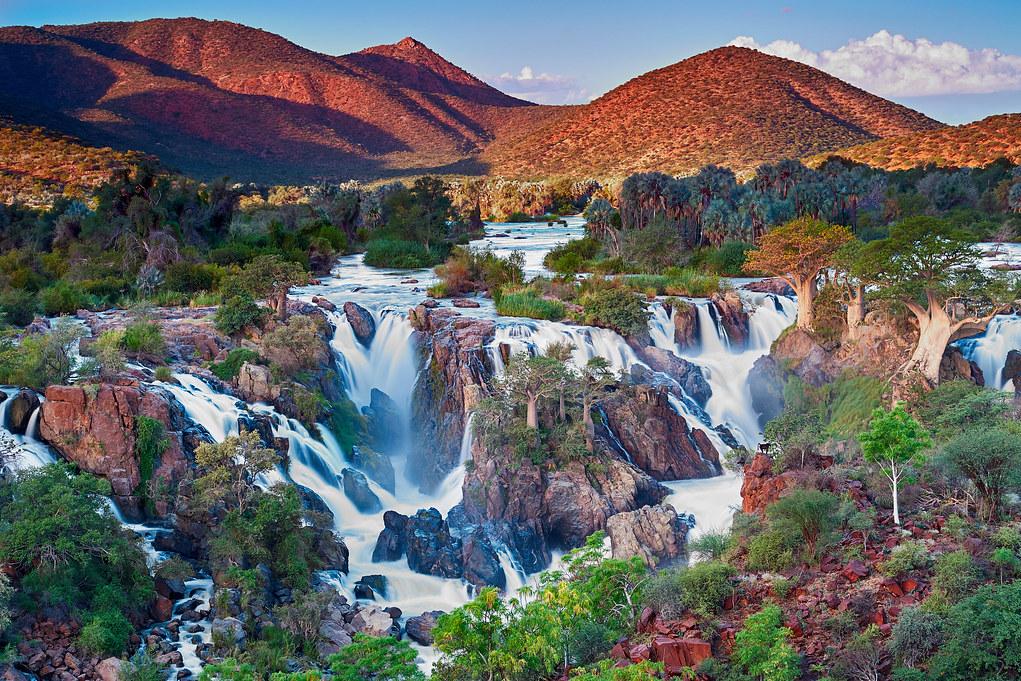 BuniChristopher's tweet photo. Namibia a desert, attracts almost the same number of tourists Uganda does. Clearly, beating up journalists &amp; teargas as you sit in traffic jam for hours to go to overpriced grass thatched lodges cannot be the icing. (Picture is the Epupa falls in Namibia) https://t.co/fIuoiKkwWh