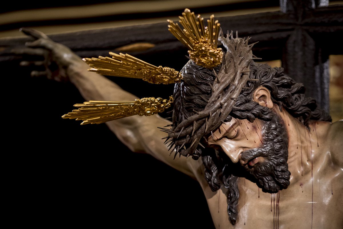 Hdad_Trinidad's tweet photo. 🔴🔵 #𝘼𝘾𝙏𝙐𝘼𝙇𝙄𝘿𝘼𝘿 l EL SANTÍSIMO CRISTO DE LAS CINCO LLAGAS PRESENTA POR PRIMERA VEZ POTENCIAS JUNTO A LA CORONA DE ESPINAS

La Imagen del Santísimo Cristo de las Cinco Llagas se presenta, por primera vez desde su hechura por el imaginero D. Luis Álvarez Duarte en el año 2002, con potencias junto a la corona de espinas.

Con la colocación de las potencias se culmina su iconografía, cargada de simbolismo teológico y reforzando la concepción de Cristo como Rey y Salvador, resaltando su divinidad incluso en los momentos de su pasión y sufrimiento.

- El significado de las potencias

Las potencias son un atributo esencial en la iconografía cristiana, expresan la divinidad de Jesucristo y su triple condición de Profeta, Sacerdote y Rey. Proceden del despiece del nimbo crucífero, cuya tradición se remonta al arte bizantino y se ha desarrollado a través de las representaciones carolingias, románicas y góticas. Estas tres llamaradas de luz simbolizan la plenitud de la gracia, la omnipotencia y la omnisciencia de Cristo, atributos esenciales de su naturaleza divina.

La liturgia y la teología afirman que Jesús debe llevar en todo momento sus potencias, incluso en los pasajes en los que su humanidad fue ultrajada. La costumbre de representarlo sin ellas para enfatizar su condición humana resulta incongruente, especialmente cuando otras figuras secundarias en la escena portan aureolas de santidad. Así, el uso de las potencias reafirma su condición divina, sin opacar el sufrimiento que enfrentó por la redención de la humanidad.

- La corona de espinas: un emblema de sufrimiento y realeza

Junto a las potencias, la corona de espinas adquiere una relevancia fundamental en la iconografía pasionista. Este elemento recuerda que, a pesar de la burla de los soldados romanos, Cristo fue y es el Rey de reyes. Su imposición en la pasión no sólo representa el desprecio al que fue sometido, sino también la paradoja de su victoria a través del sacrificio. La corona de espinas simboliza su doble función: la del Siervo Sufriente anunciado en Isaías y la del Mesías Conquistador del Apocalipsis.

Además, su significado se vincula con la caída del hombre en el pecado original. En el libro del Génesis, los espinos y cardos son parte de la maldición que recayó sobre la humanidad tras la desobediencia de Adán y Eva. Así, la corona de espinas, lejos de ser un mero instrumento de tortura, se convierte en un símbolo de redención: Cristo, con su sacrificio, carga sobre sí la maldición del pecado para librar al mundo de ella.

- La conjunción de ambos símbolos

La combinación de potencias y corona de espinas en la imagen del Santísimo Cristo de las Cinco Llagas subraya una verdad teológica fundamental: Cristo es siempre Dios, incluso en los momentos de mayor humillación y sufrimiento. En esta representación se integran los conceptos de luz y sacrificio, de gloria y entrega, manifestando la plenitud del Misterio Pascual.

La presentación del Santísimo Cristo de las Cinco Llagas con potencias junto a la corona de espinas no es un simple cambio estético, sino una reafirmación de su naturaleza divina y su realeza eterna. Por ello, los hermanos de la Trinidad en el Cabildo General celebrado el pasado 12 de enero de 2025 acordaron recoger en el reglamento sobre la Estación de Penitencia la obligatoriedad de que la imagen porte sus atributos de divinidad, a través de unos elementos en los que de forma rotunda se sintetiza el misterio de la Pasión: la aparente derrota que en realidad se convierte en el triunfo definitivo sobre el pecado y la muerte.

#𝙏𝙧𝙞𝙣𝙞𝙙𝙖𝙙𝙎𝙚𝙫𝙞𝙡𝙡𝙖 #𝙎𝙤𝙮𝙙𝙚𝙡𝙖𝙏𝙧𝙞𝙣𝙞𝙙𝙖𝙙 #𝙎𝙥𝙚𝙨𝙉𝙤𝙣𝘾𝙤𝙣𝙛𝙪𝙣𝙙𝙞𝙩