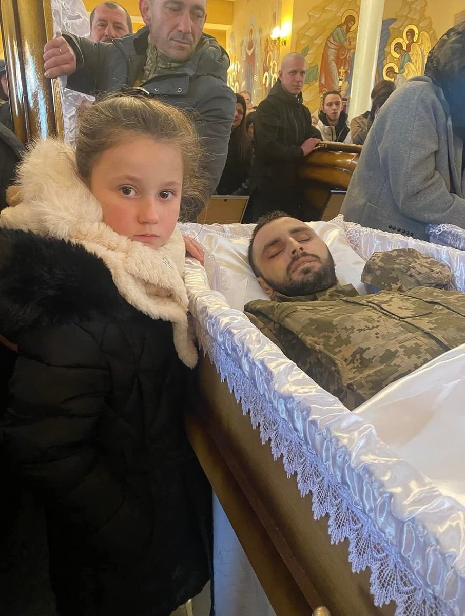 Rusya'ya karşı savaşta ölen babasının yanında duran Ukraynalı çocuk.