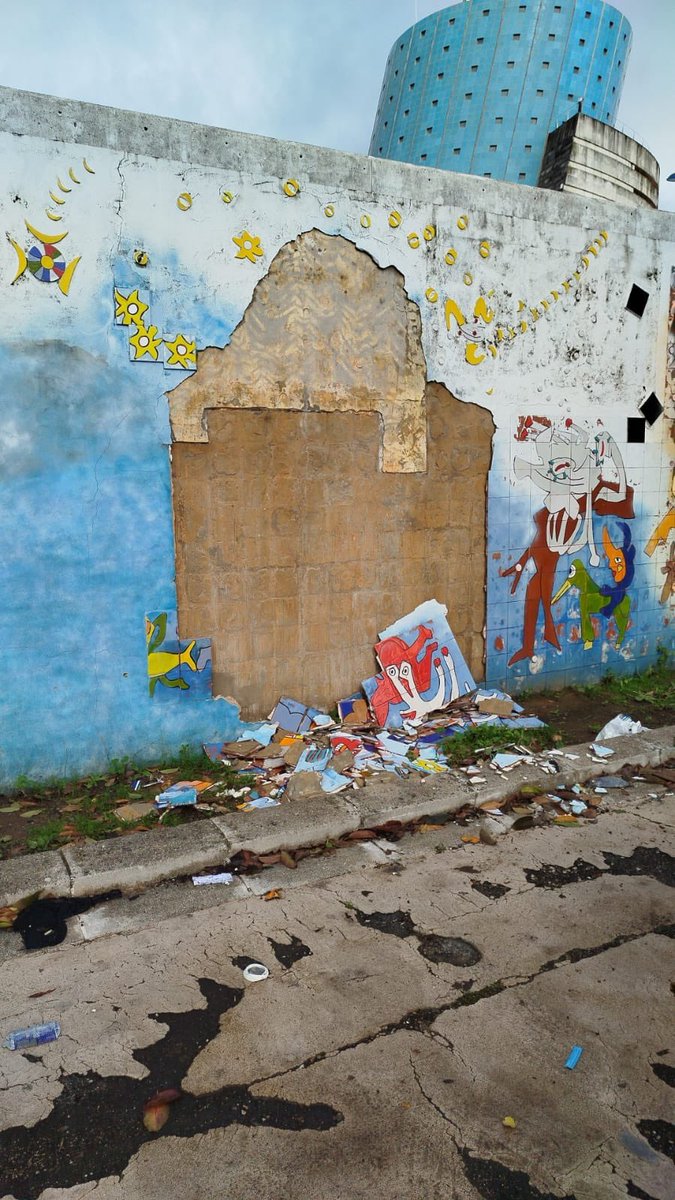 Se ha desprendido una parte muy significativa del mural Verbo América. La Puerta de la Barqueta espera desde hace años un proyecto de puesta en valor que permanece guardado en los cajones del <a href="/Ayto_Sevilla/">Ayuntamiento de Sevilla</a> mientras la zona es pasto del aparcamiento indiscriminado y el abandono,