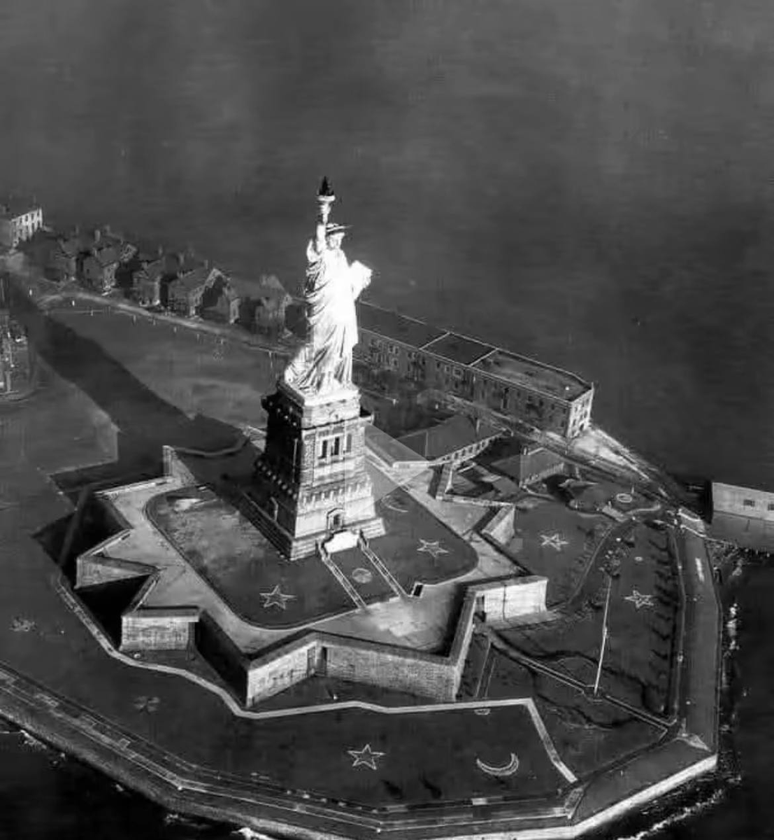 On top of the a Star Fort, surrounded by the moon and stars is the Statue of Liberty.

The torch represents the flame of knowledge, which Lucifer gave to his followers in order to maintain his cult. The left foot on the statue is chained up.  This represents when the Creator