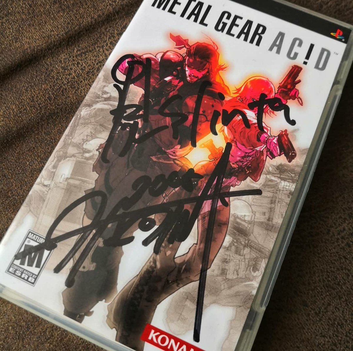 Usiiruk's tweet photo. @StealthBoomBoom Still remember as Hideo Kojima and Shinta Nojiri were at the Games Convention in Leipzig Germany and both signed my PSP copy of the game! And since it was my 27th birthday they presented me with a Konami watch &amp; a limited edition Zippo lighter with Metal Gear Acid etched into it! https://t.co/fA49Qv7f00