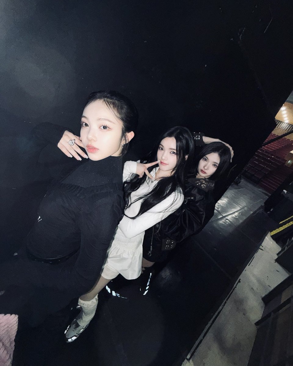 eongjian's tweet photo. Standing in the dim glow backstage, with Yuha unnie and Jiwoo unnie beside me, we create our own little world. Shadows dance around us, but our energy shines through. Just three souls sharing the same stage, the same dream, and endless memories.    (...)⠀ 𓍯  .  ݁    ✦ https://t.co/wcSy5mz0Qt