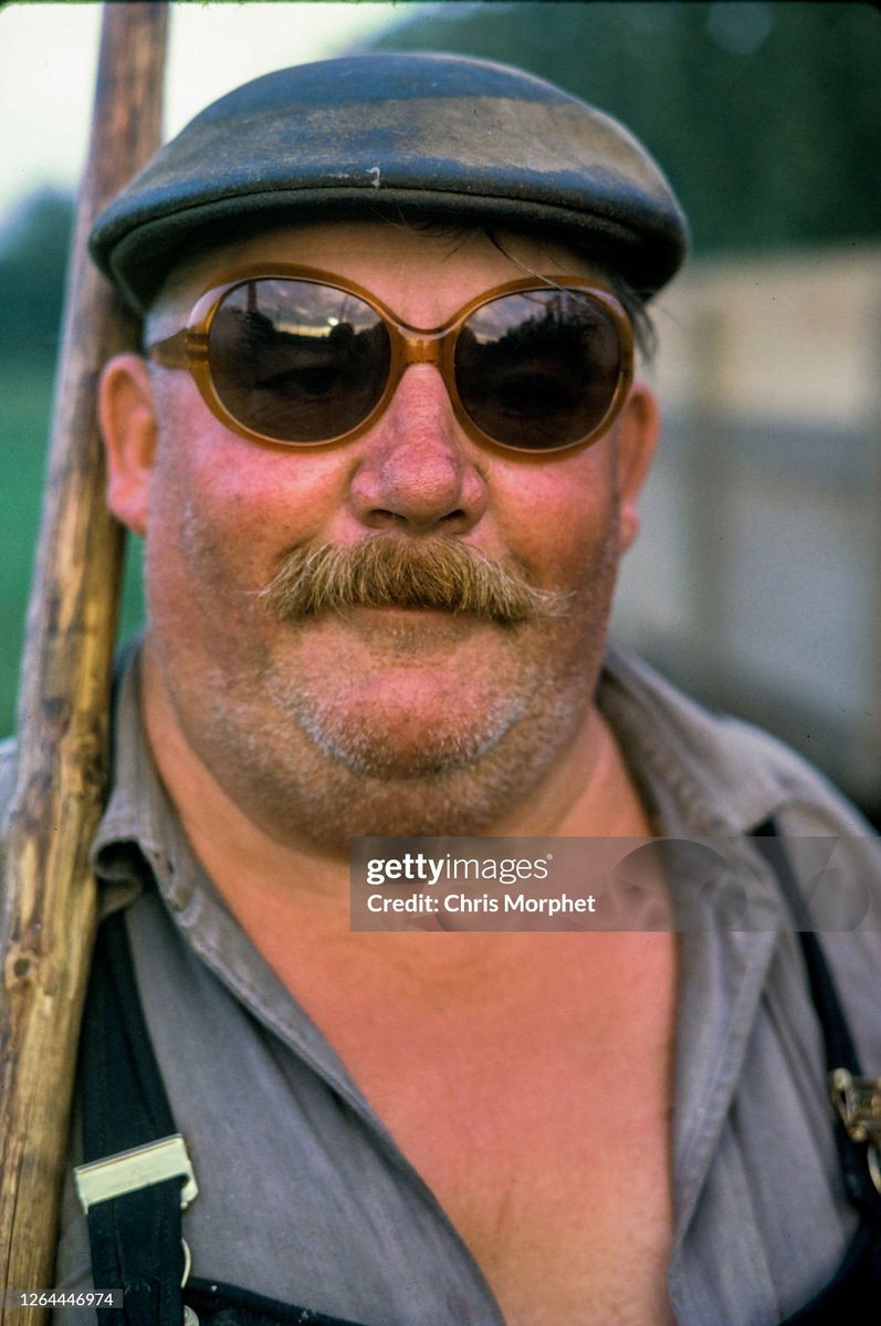 A hop picker stands with a pole in a hops field on a farm near Cranbrook in Kent (1970)