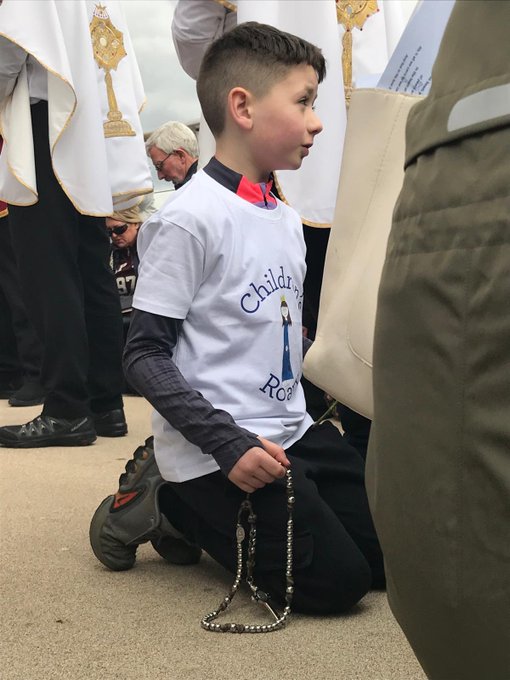 😍 Un niño reza el Rosario durante la procesión eucarística por Athlone, Irlanda, conmemorando el Día de San Patricio.