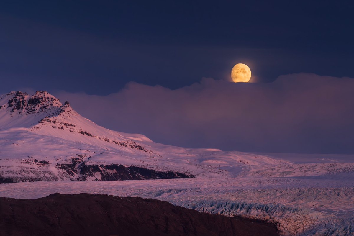 En este último viaje a Islandia pude tomar esta foto de ensueño con la luna ocultándose entre las nubes, y con vista a los glaciares iluminados con las primeras luces del día.