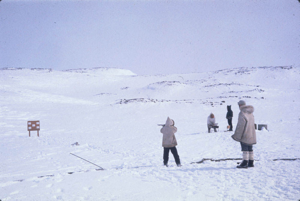 A young Inuk takes a shot at a target during a competition in Kinngait, Nunavut. 

Photo by Charles Gimpel. April 24, 1964.