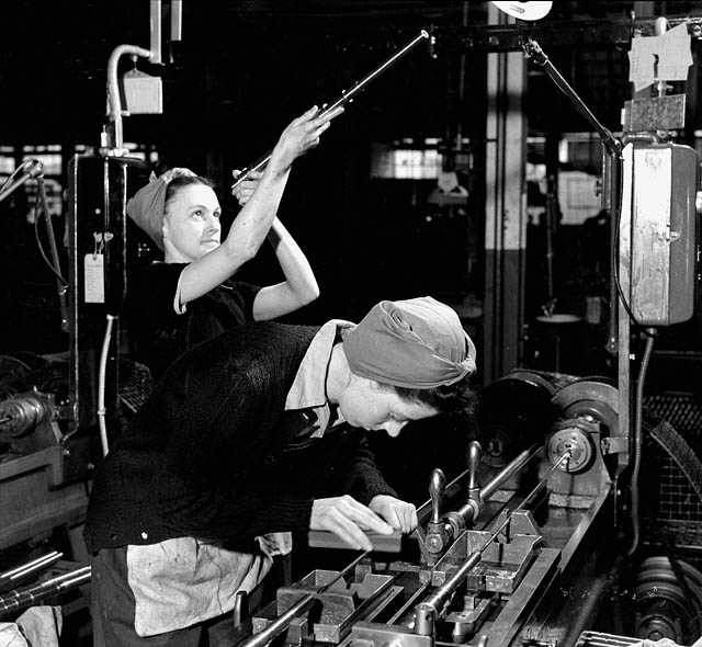 Woman checks the interior of a Bren barrel while another adjusts the boring machine. John Inglis Bren Plant in Toronto, Ontario.

April 9, 1941. National Film Board.