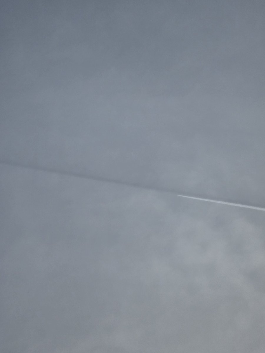 Notice the dark line above the spraying airplane?