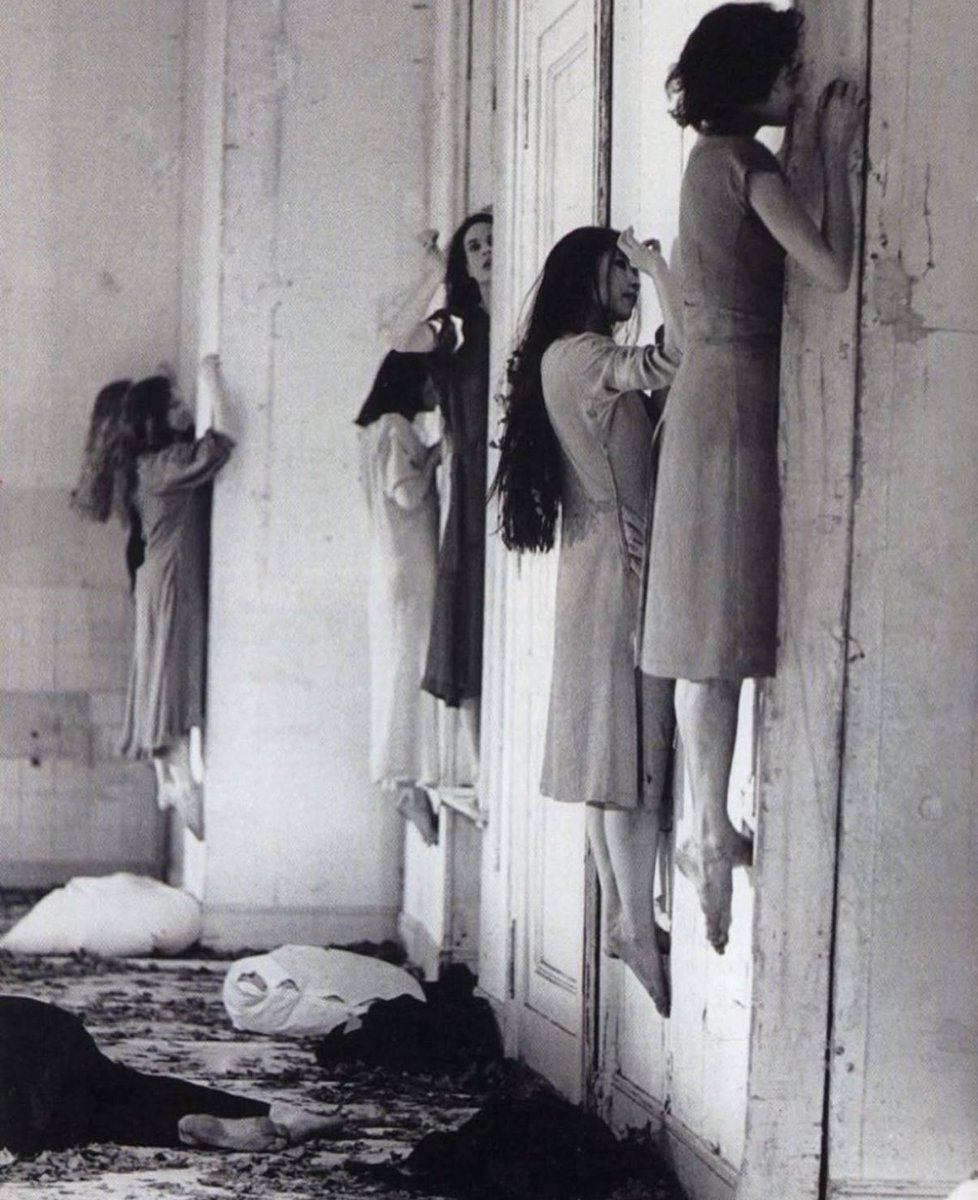 historyinmemes's tweet photo. In Pina Bausch's 1977 dance-theater piece Bluebeard, a man (Bluebeard) obsessively plays and rewinds a tape of Béla Bartók's opera while interacting with dancers, especially a woman portraying his captive bride. The stage, covered in debris, reflects decay and confinement. Through raw, repetitive movements, the dancers express control, submission, and resistance. Blending dance and theater, Bausch uses fragmented gestures, spoken words, and intense emotions to explore power, love, and destruction in relationships.