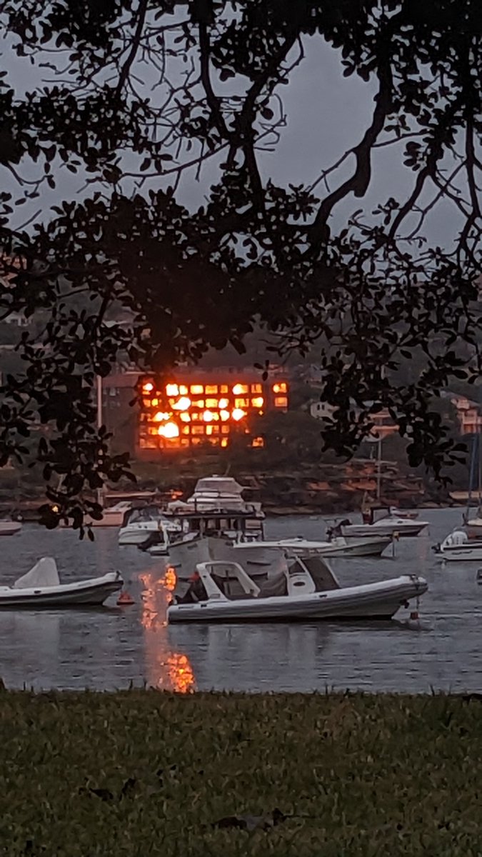 The sun reflecting off of a building and the water, looks like fire