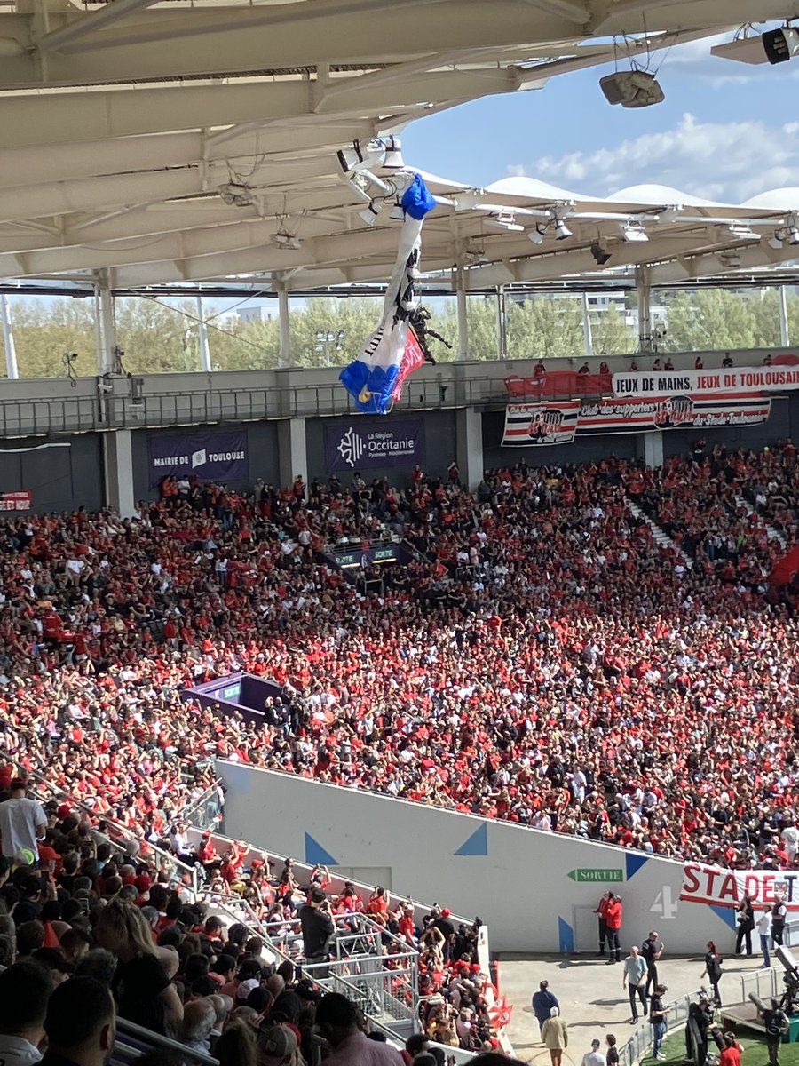 Issue here at Toulouse as the third in a series of paratroopers has got themselves stuck on top of the stadium. Nobody seems worried yet but looks pretty concerning.