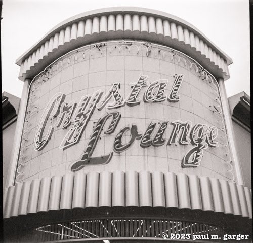 The old neon sign beckons one and all, live poker nightly at the Crystal Lounge. Caught on film with a Kodak 66 camera, expired Tri-x film and developed in caffenol.