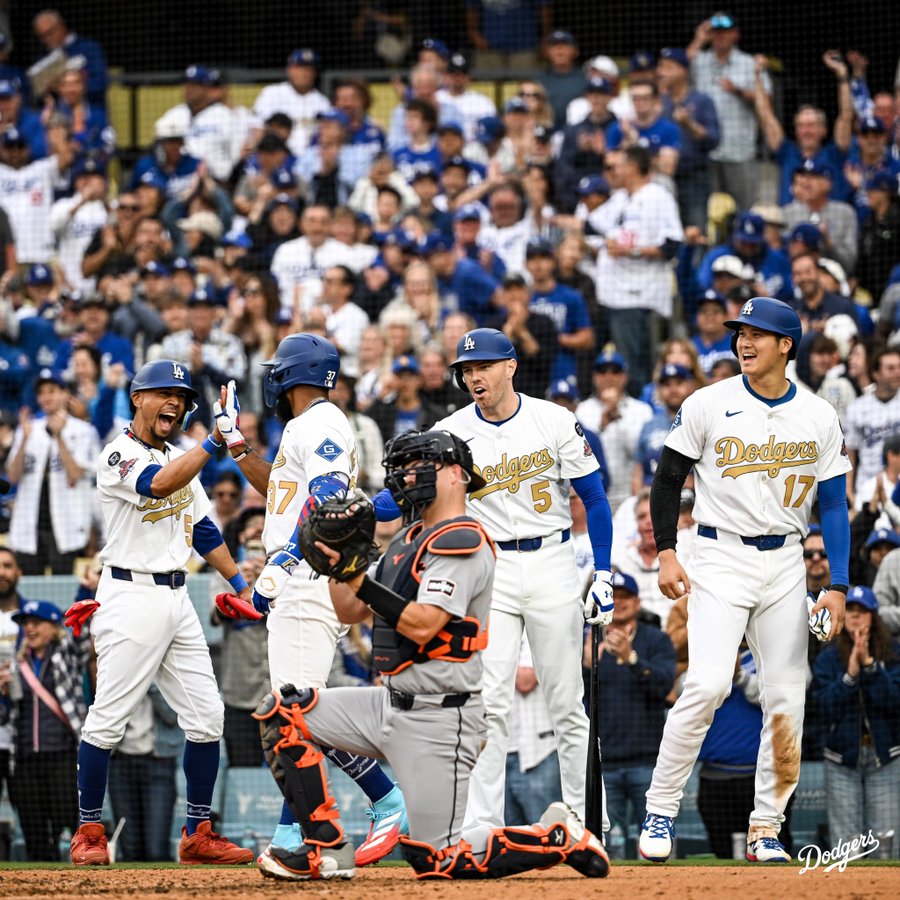 A photo of Mookie Betts, Freddie Freeman and Shohei Ohtani greeting Teoscar Hernández at home plate after he hit a home run.