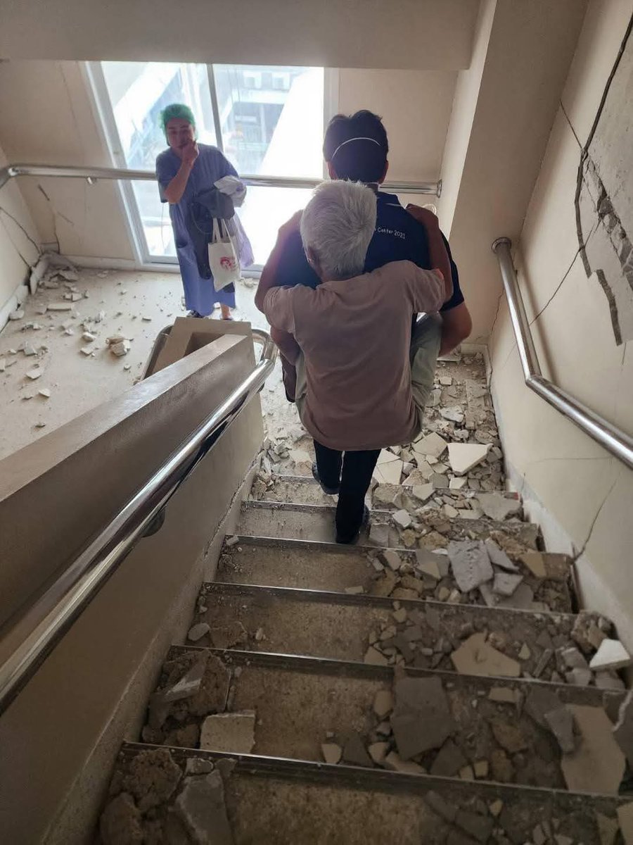 หนึ่งภาพล้านความหมาย มันไม่ได้หนักแค่กทม.ทุกพท.ตามแนวรอยต่อของแผ่นดินไหวก็หนักเหมือนกัน ที่รพ.ลำปางคุณหมอถวัลย์ staff ศัลยกรรม ให้คนไข้ขึ้นหลัง นำลงบันไดมาด้านล่าง น่าชื่นชมมากคุณหมอไม่เคยทิ้งคนไข้บริการด้วยหัวใจอย่างแท้จริง (นายแพทย์ถวัลย์ จุฑาศิลปารัตน์