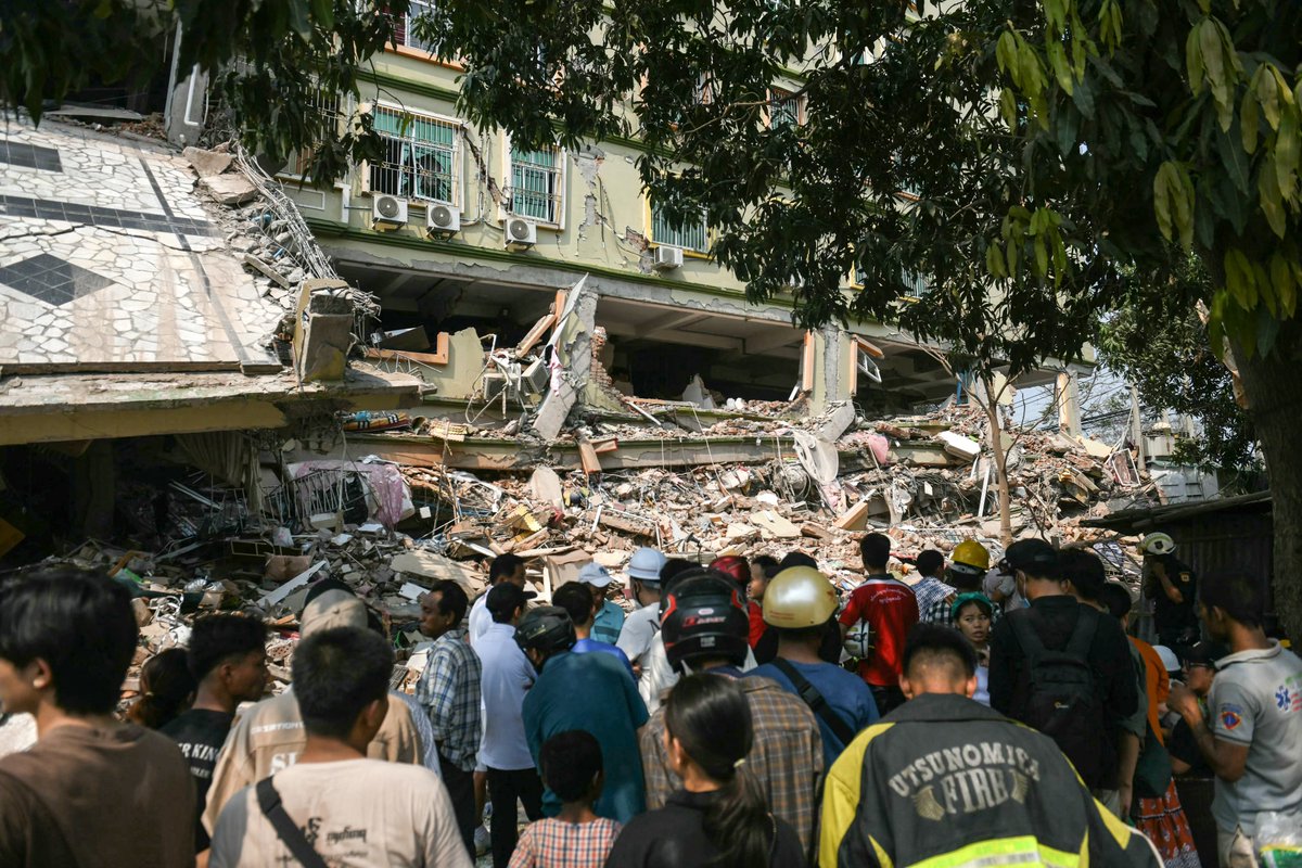 MizzimaNews's tweet photo. More than 90 people could be trapped inside the crushed remains of an  apartment block in #Mandalay in central #Myanmar destroyed by a  devastating #earthquake, a #RedCross official told AFP on Saturday as  rescuers worked to free the victims. Photos: AFP https://t.co/r5heYa7snA