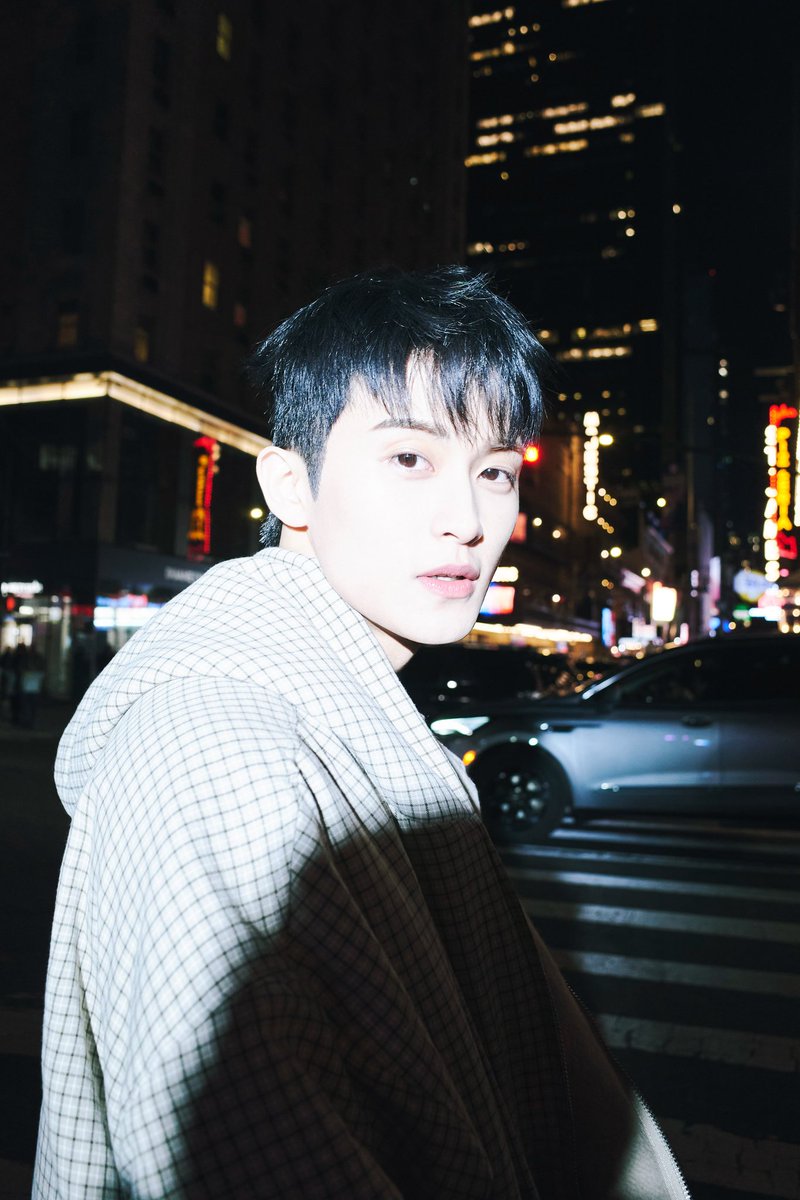 Looking up at the towering lights, a sense of solitude washes over.  The city's a dreamscape at night, a place to get lost in your own thoughts.  A quiet moment of reflection, framed by the neon glow.  Alone, but not lonely.