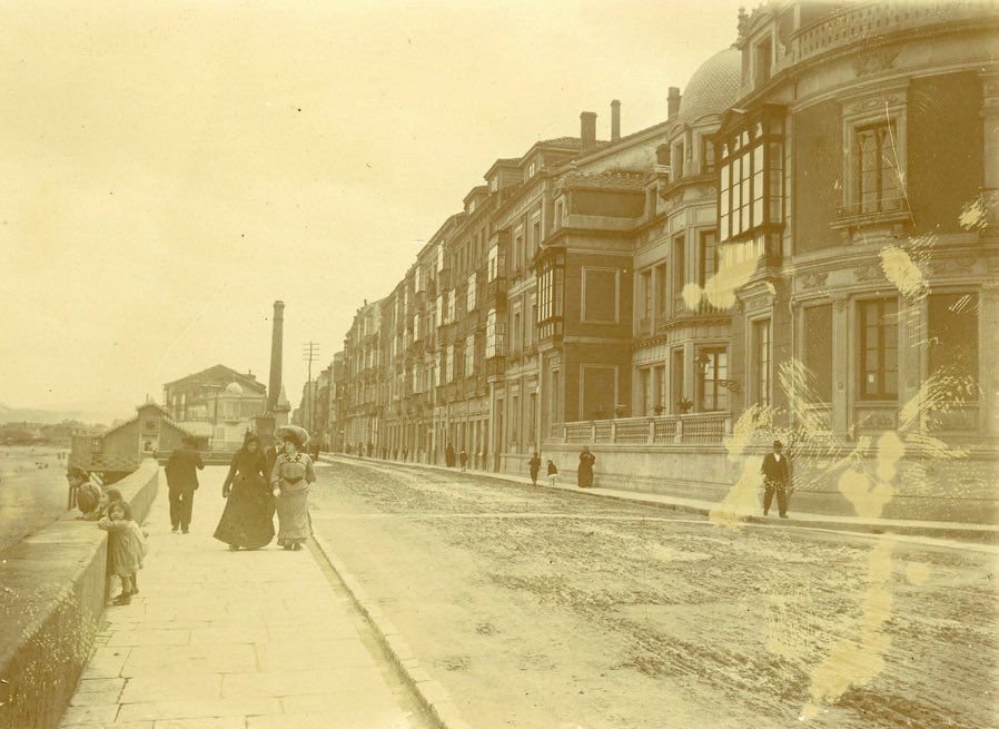 Fotografía anterior a 1907 donde se observa el paseo del muro de la Playa de San Lorenzo en construcción. La playa, que era privada, está cercada por un murete.
