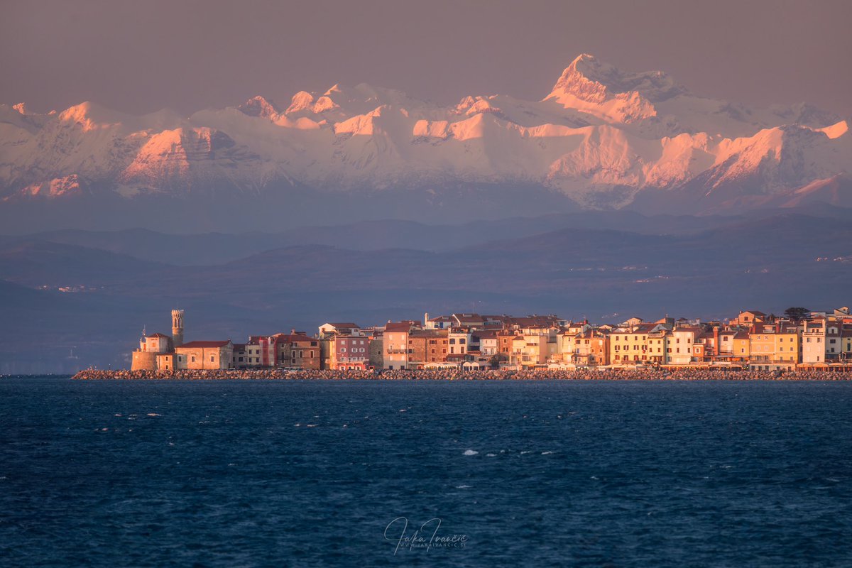 Piran in Alpe – brez Photoshopa, brez umetne inteligence. Samo 500 mm objektiv, prava lokacija in odlična zimska vidljivost.

500 mm teleobjektiv stisne perspektivo in približa oddaljene elemente, kar ustvarja skoraj nadrealističen učinek.