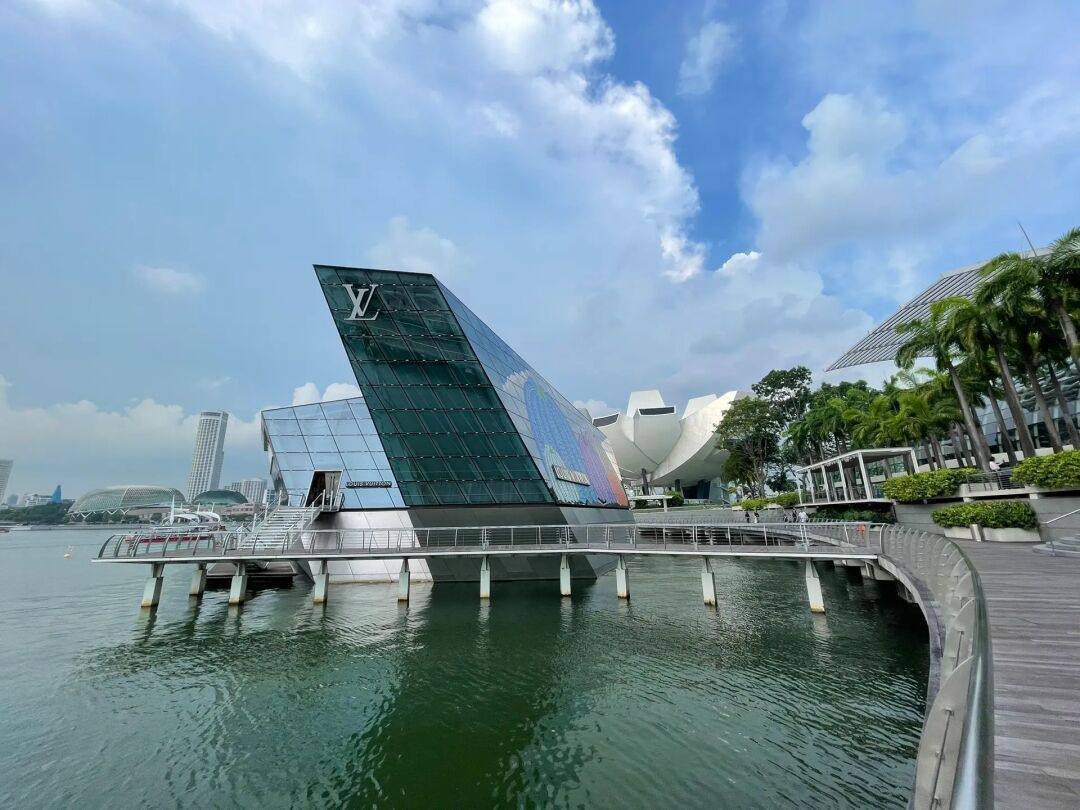 The lake reflects the glass building, where modernity and nature blend quietly.