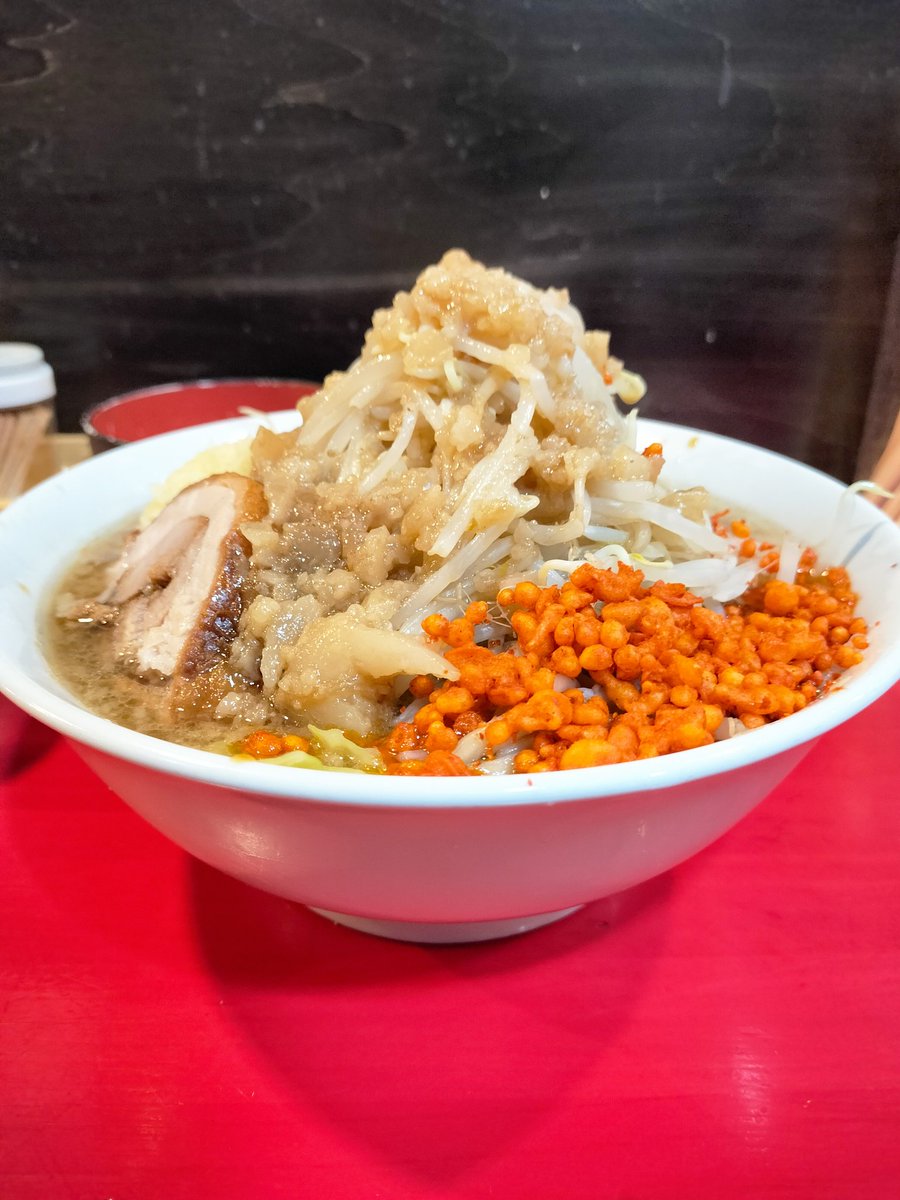 Recomen_neko's tweet photo. 【お店紹介 その42】
鷹の目 大宮店
ラーメン(小)豚入り 1100円 全マシ

関東を拠点に展開されている鷹の目さん、パンチの効いた非乳化スープと辛い揚げ玉［辛揚げ］が特徴のラーメン屋さんです！

個人的にかなり好みな一杯、このラーメンは全ての要素でしっかり及第点を叩き出してくれる！私はそう思っております。
まずは細め硬めの麺、他の二郎系、また直系店と比べると細めのため食べやすく、且つ麺量は小で300gしっかり入るので、通常よりも多く麺をすすった感覚となります！そのため小でも満足感しっかりです😆細めの麺を提供していただける店舗さんはこれが良いポイントだと個人的には思います！

スープは非乳化！醤油感はしっかりありながら、動物系の旨味が全面に感じられてとても美味しいです！！
デフォルトでも液アブラがかなり入るので、コッテリ感も申し分無しです！味も濃いめなので、下から麺を引き上げてすすれば唸るほど美味しい！！
このスープ、ニンニクとも相性バツグンなので、私は途中でニンニクを絡めることでさらに味を引き締めます！ニンニクは辛すぎず、けどちゃんと風味を出してくれる美味しいヤツです◎自分の予定と相談して増せたらぜひ増してみてください！

ヤサイは通常でも比較的多く乗ります。マシマシではかなりの量が増されるので、自分のキャパと要相談です🤔
もやしメインですが旨みをまとっており、カエシやアブラと一緒にかき込むとめちゃウマです！！
アブラはやや味付きなので、ヤサイだけでなく麺とも、またスープに浸してコッテリ度を高めるのもGood👍マシマシには50円必要とのことですが、払う価値大アリです！

そして最大の特徴でもある辛揚げ！辛い揚げ玉ですが、ラーメンのアクセントとなり大変美味しいです！
辛味が足されることによって口内はてんやわんやです。ヤサイを食べ進める手助けにもなりますし、麺とすすってもさらなるジャンキーさを楽しめます！
当たり前ですがちょい辛なのでご注意🌶生たまごも頼むとマイルドになって丁度良かったです！おすすめ！

豚は厚切りのジューシーなヤツ🐷これが美味い！！味付きですし肉厚ホロホロです！！みんなが好きなやつ！！
豚マシしたい！！でもちょっと大判サイズなので、美味しく食べられる範囲で追加するのがベストですね

ご自身のお向かいやすい店舗さんにぜひ足をお運びください！個人的にかなりオススメな非乳化の一杯です！