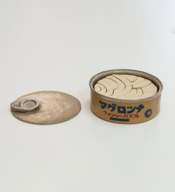 ツナ缶のパズルに漆で色を加えました。缶に銀蒔絵、側面に手書き文字をあしらいました。下地工程を省き木目を活かしてざらついた銀蒔絵でヴィンテージ感を演出。木目を活かしながらも金属感を巧みに融合させた仕上がりとなりました。

#ツナ缶のパズル