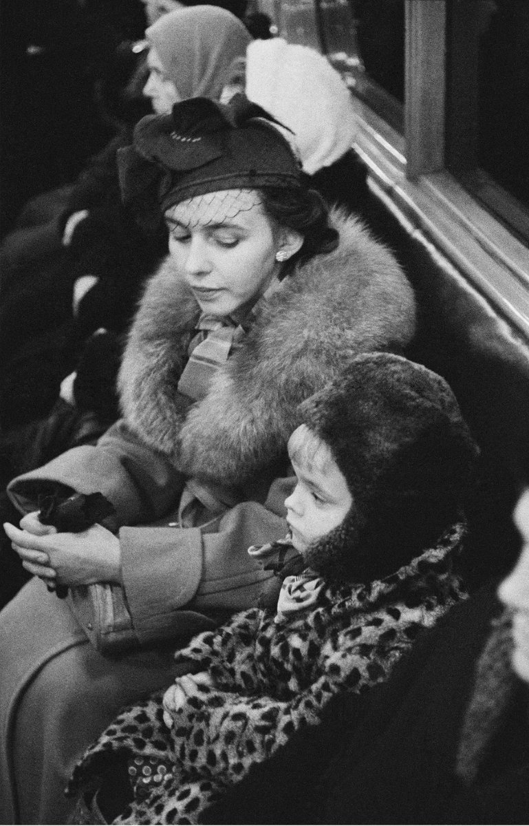 An elegant lady with a child in the Moscow metro, 1955.
