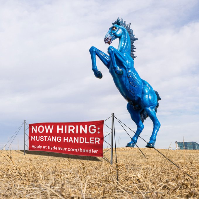 DEN's Mustang statue with a hiring sign in front of it that reads, "Now Hiring: Mustang Handler. Apply at flydenver.com/handler."