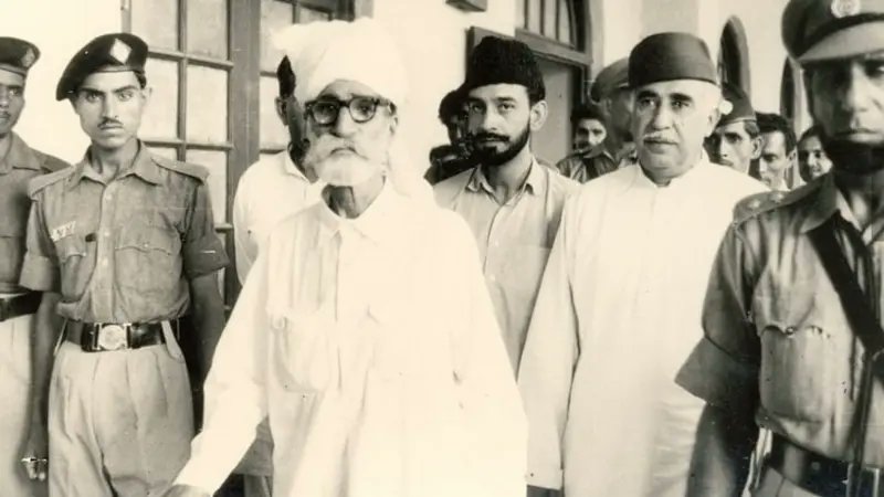 QasimKhanSuri's tweet photo. نواب نور��ز اور ان کے ساتھیوں کو پہاڑوں سے اتارنے کے لیے کیا طریقہ اختیار کیا گیا؟

بریگیڈیئر ریاض حسین نے جو کہ اس وقت آپریشن کے کمانڈر تھے مسائل کو مذاکرات کے ذریعے حل کرنے پر زور دیتے ہوئے وعدہ کیا کہ حکومت پاکستان کے ساتھ کامیاب مذاکرات اور سمجھوتے کے نتیجے میں سوراب تا لسبیلہ ایک نئی ریاست تشکیل دے کر اسے نواب نوروز کے ماتحت کیا جائے گا اور ان کی حیثیت ایک بااختیار حاکم ( یعنی نواب آف مکران) کے برابر ہوگی اور مقامی انتظامیہ اور دیگر ریاستی امور ان کے ماتحت ہوں گے۔

’جواب میں نواب نوروز نے لکھا کہ میں بلوچی رسم و رواج اور تشخص کا سودا ہرگز نہیں کروں گا۔ یہ ہماری سر زمین ہے جس کے ٹکڑے کرنے کے حق میں نہیں ہوں۔‘ نوروز خان نے کہا کہ ’اگر حکومت مذاکرات کی خواہشمند ہے تو پہلے اپنی فوجیں واپس بلا لے، خان آف قلات کو فوری طور پر رہا کرے، حکومت قلات کی حاکمیت بحال کرے اور بلوچستان کے تمام گرفتار شدہ قیدیوں کو رہا کرے۔‘

جب مراعات کی پیشکش کے باوجود نواب نوروز خان بات ماننے کے لیے تیار نہیں ہوئے تو ایک جرگہ نواب نوروز کے ��اس بھیج دیا گیا اور جرگہ کی گود میں قرآن مجید کو بطور ضامن رکھ کر بھیجا گیا کہ وہ اس کی ضمانت پر پہاڑوں سے اتر جائیں۔

کتاب کے مطابق جب مسلح کاروائیاں کرنے والے نیچے آئے تو انھوں نے قرآن مجید کو بوسہ دیا اور کہا کہ ہم اس کا صدقہ اتاریں گے مگر ہتھیار نہیں ڈالیں گے، سرکاری وفد ان کو مسلسل قرآن کا واسطہ دے کر یہ یقین دلاتا رہا کہ حکومت اپنے وعدے پر قائم ہے۔

ڈاکٹر شاہ محمد مری نے کہا کہ ’نواب نوروز اور بلوچوں نے کہا کہ جب قرآن کو ضامن بنا رہے ہیں تو اس سے بڑھ کر کیا ضمانت ہوگی اس لیے جب وہ نیچے آئے تو پھر حکومت اپنے وعدوں سے پھر گئی اور ان کو گرفتار کیا گیا۔‘

گرفتاری کے بعد نواب نوروز خان سمیت بڑی تعداد میں لوگوں کو کوئٹہ کے قلی کیمپ منتقل کیا گیا جب نواب نوروز خان کو لایا گیا تو اس میں سات سو افراد کو رکھا گیا تھا، کتاب م��ں دعویٰ کیا گیا ہے کہ مسلسل آٹھ ماہ تک قلی کیمپ میں ٹارچر کے بعد ان کو سینٹرل جیل مچھ منتقل کیا گیا۔

ڈاکٹر مری کے مطابق گرفتاری کے بعد نوروز خان اور ان کے ساتھیوں کو ان اذیت خانوں میں منتقل کیا گیا جو کہ جاپانیوں کو ٹارچر کرنے کے لیے انگریزوں نے بنائے تھے، ملٹری کورٹ سے نوروز خان کو بڑی عمر کی وجہ سے عمر قید جبکہ بیٹے سمیت ��ات دیگر ساتھیوں کو سزائے موت دی گئی اور تمام قیدیوں کو سکھر اور حیدرآباد جیل منتقل کیا گیا۔
جب جیل سپرینٹنڈنٹ نواب نوروز خان کے پاس تعزیت کرنے آئے اور کہا کہ آپ کے بیٹے اور ساتھیوں کو پھانسی ہوئی ہے تو نواب نوروز خان نے پھانسی پانے والے اپنے بیٹے کی مونچھوں کو اوپر کرتے ہوئے کہا کہ 'صرف بٹے خان نہیں بلکہ یہ سب میرے بیٹے ہیں، یہ مرے نہیں بلکہ ان کی شادی ہے، مرے وہ لوگ ہیں جنھوں نے قرآن مجید پر فیصلہ کرنے کے بعد ان کے ساتھ دھوکہ کیا۔'

اپنے بیٹے سمیت سات افراد کو پھانسی کے پانچ سال بعد نواب نوروز 25 دسمبر 1965 کو حیدرآباد جیل ہی میں وفات پا گئے، حیدر آباد جیل میں وفات پانے کے بعد نواب نوروز کی لاش کی بھی قلات میں پھانسی پانے والے سات افراد کے ساتھ تدفین کی گئی، نوروز خان نے حیدرآباد جیل میں بھی معافی کی پیشکش کو مسترد کیا۔

'نواب نوروز اور ان کے ساتھی' نامی کتاب کے صفحہ نمبر 72 پر حیدرآباد جیل کے اس وقت کے سپرینٹنڈنٹ راشد سعید کے تاثرات درج ہیں، راشد سعید کے حوالے سے کتاب میں کہا گیا ہے کہ ’آخری دم تک یہ کہا گیا کہ تم معافی مانگ لو ہم نہ صرف تمہاری سرداری اور جاگیرداری بحال کریں گے بلکہ تمہیں اور تمہارے بیٹوں کو آزاد کریں گے، مگر وہ بھی دھن کے پکے تھے انھوں نے یہ پیشکش یہ کہہ کر رد کر دی کہ اگر میرے مولا کی طرف سے یہی لکھا ہے تو یہ مجھے منظور ہے۔‘

کتاب: 'نواب نوروز خان اور ان کے ساتھی'