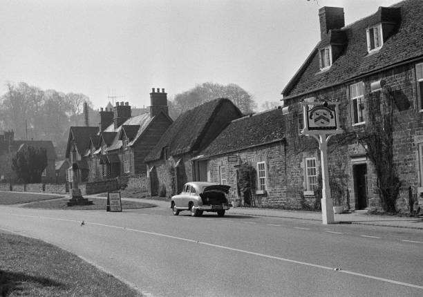 Britains___Pubs's tweet image. A car parked outside the Sondes Arms pub in the village of #Rockingham in #Northamptonshire, #England on 17th May 1958.
