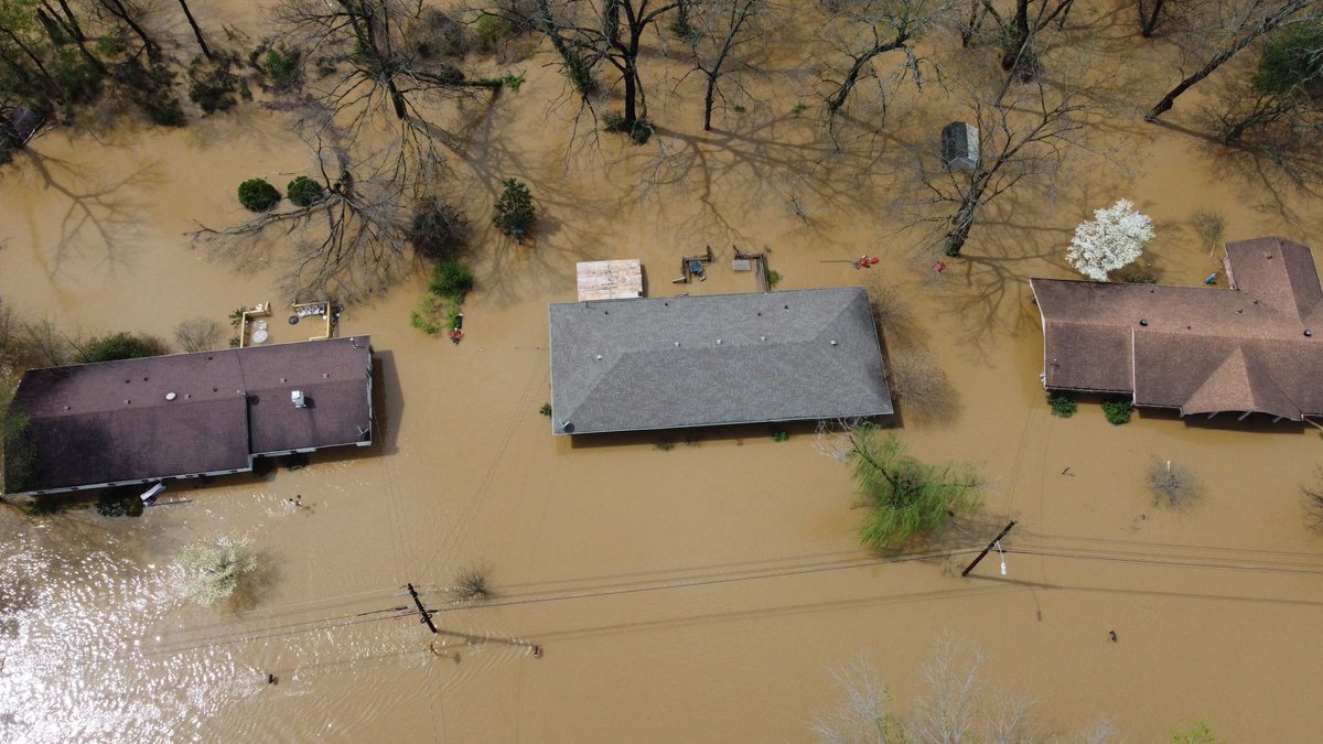 ZRLancaster's tweet photo. My sister just lost everything to the flood and now my mom's is going under. Their all at my Granny's which is on the same road. The water will reach her house tonight and idk what's next. What a nightmare.  The grey roof is my sister's and of course Mom lives across from her. https://t.co/JTwFLqKHzS