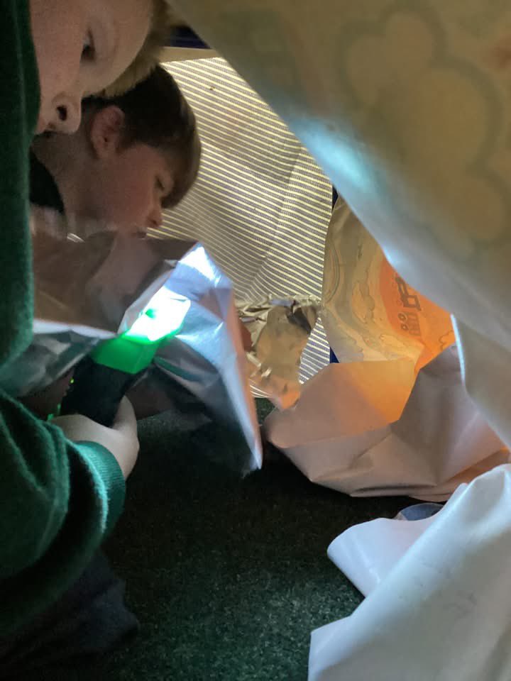 Today's learning in class 2 went under the table!  We scientists were testing materials in the dark to see if they were transparent (letting the light through) or opaque (not letting the light through).  Can you find any transparent objects in your home?